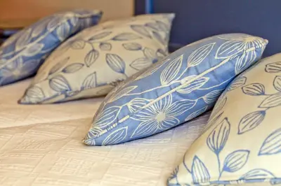 a bed with blue and white pillows on it at Casa dos Cardos in Luz