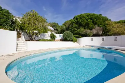 a swimming pool with blue water in a yard at Casa dos Cardos in Luz