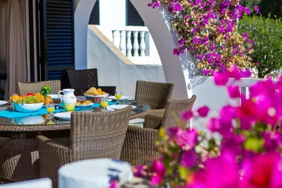 a table with food and flowers on a patio at Casa dos Cardos in Luz