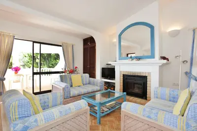 a living room with blue and white furniture and a fireplace at Casa dos Gemeos in Luz