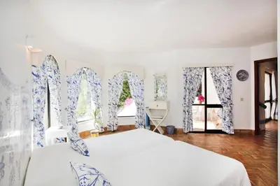 a bedroom with two white beds and blue and white curtains at Casa dos Gemeos in Luz