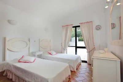 two beds in a white room with a window at Casa dos Gemeos in Luz