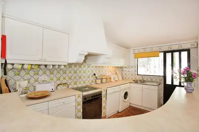 a kitchen with white cabinets and a sink at Casa dos Gemeos in Luz