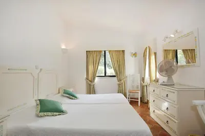 a bedroom with two beds and a dresser and a mirror at Casa dos Gemeos in Luz