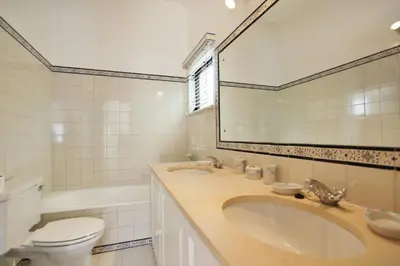 a bathroom with a sink and a toilet and a mirror at Casa dos Gemeos in Luz