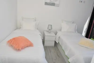 two beds with white sheets and an orange blanket on them at GuestReady - Sonho dos Avós in Câmara de Lobos
