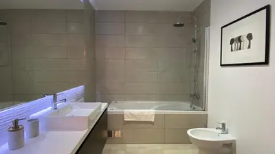 a bathroom with a tub and a sink and a toilet at Madeira Mero Apartment in Caniço