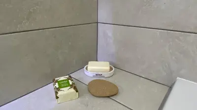 a bathroom with a toilet and a cookie on the floor at Madeira Mero Apartment in Caniço