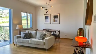 a living room with a couch and a table at Madeira Mero Apartment in Caniço