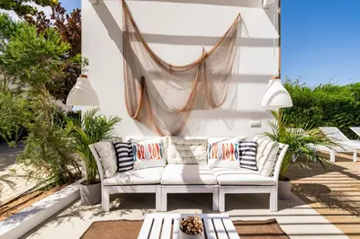 a patio with a white couch and a hammock at Casa Vica - Sagres Apartments in Sagres