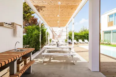 a patio with a table and benches next to a pool at Casa Vica - Sagres Apartments in Sagres