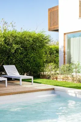 a white bench sitting next to a swimming pool at Casa Vica - Sagres Apartments in Sagres