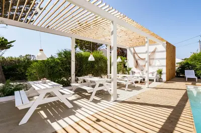 a white pergola with a table and chairs next to a pool at Casa Vica - Sagres Apartments in Sagres