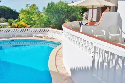 a swimming pool on the side of a white fence at Casa Catryn in Luz