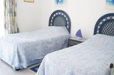 a bedroom with two beds with white comforters at Casa Catryn in Luz