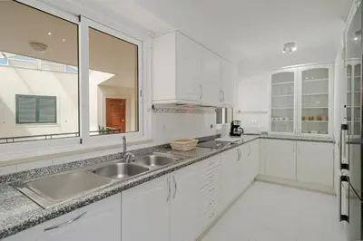a white kitchen with a sink and a window at Reis Magos V by An Island Apart in Caniço