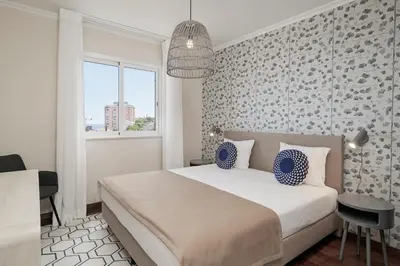 a bedroom with a large bed and a window at Reis Magos V by An Island Apart in Caniço