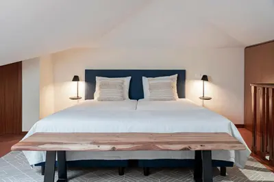 a bedroom with a large bed with a blue headboard at Reis Magos V by An Island Apart in Caniço