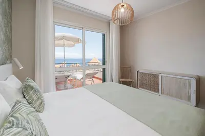a bedroom with a bed and a view of the ocean at Reis Magos V by An Island Apart in Caniço