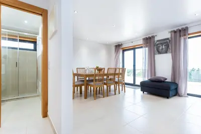 a kitchen and dining room with a table and chairs at Casa Chic in Vila do Bispo