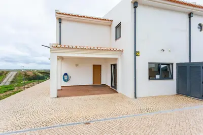 a white house with a door and a patio at Casa Chic in Vila do Bispo