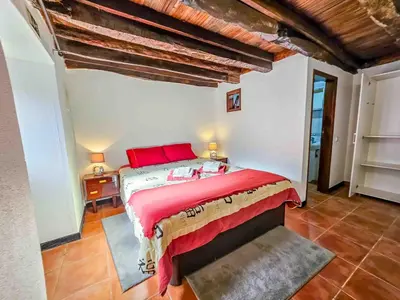 a bedroom with a bed with red pillows on it at Refúgio do Vale in Ribeira Brava