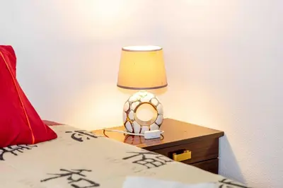 a lamp on a night stand next to a bed at Refúgio do Vale in Ribeira Brava