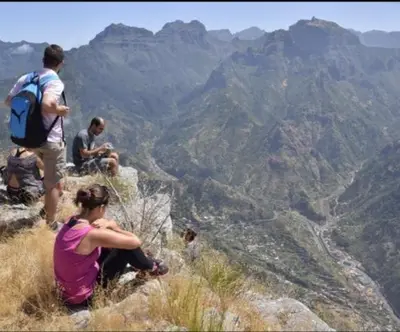 a group of people sitting on top of a mountain at Refúgio do Vale in Ribeira Brava
