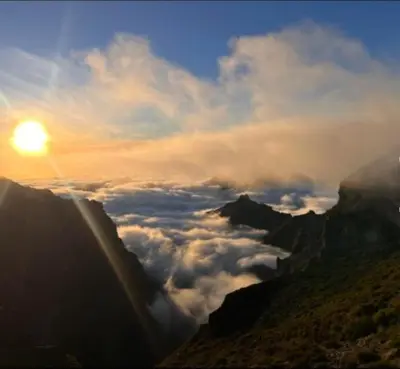 a view of a mountain with the sun above the clouds at Refúgio do Vale in Ribeira Brava