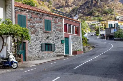 a motorcycle parked next to a building on a street at Refúgio do Vale in Ribeira Brava