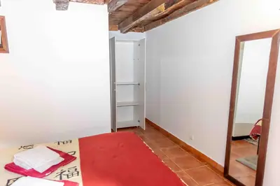 a bedroom with a mirror and a red rug at Refúgio do Vale in Ribeira Brava