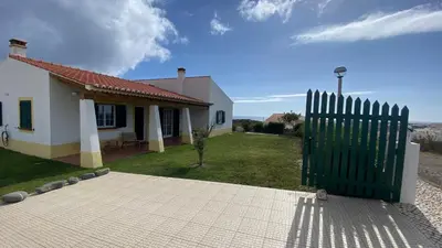 a house with a green gate in front of it at Arrifana Beach Break in Aljezur