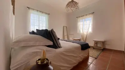 a bedroom with a bed and two windows at Arrifana Beach Break in Aljezur