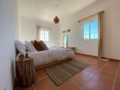 a bedroom with a bed and a table in it at Arrifana Beach Break in Aljezur