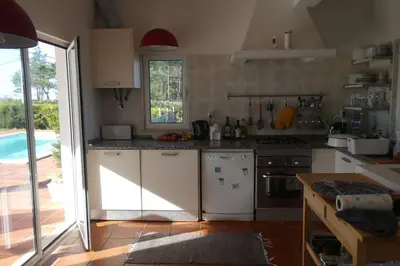 a kitchen with white appliances and a pool at Casa Colina, walking distance to Arrifana Beach in Aljezur