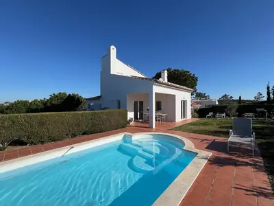 a villa with a swimming pool in front of a house at Casa Colina, walking distance to Arrifana Beach in Aljezur