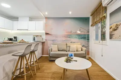 a kitchen and living room with a couch and a table at Funchal Tropical Apartments by Homie in Funchal