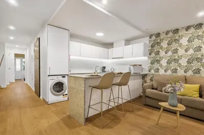a kitchen and living room with a couch and a table at Funchal Tropical Apartments by Homie in Funchal