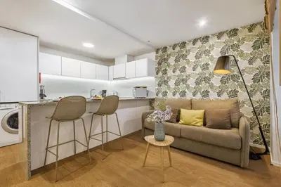 a living room with a couch and a kitchen at Funchal Tropical Apartments by Homie in Funchal