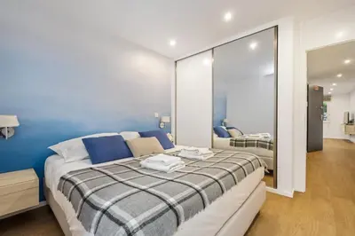 a bedroom with a bed with blue walls and a mirror at Funchal Tropical Apartments by Homie in Funchal