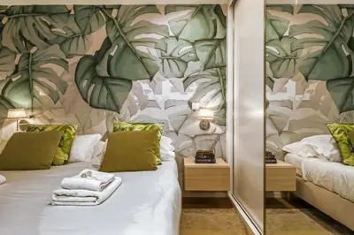 a bedroom with two beds and a mirror at Funchal Tropical Apartments by Homie in Funchal