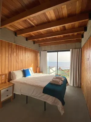 a bedroom with a large bed and a large window at Casa Pereirinha in Estreito da Calheta