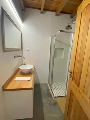 a bathroom with a sink and a glass shower at Casa Pereirinha in Estreito da Calheta