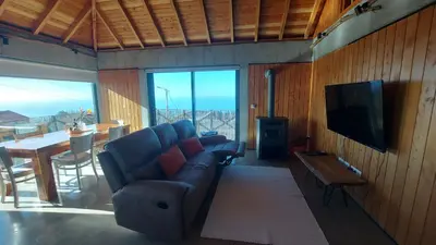 a living room with a couch and a tv and a table at Casa Pereirinha in Estreito da Calheta