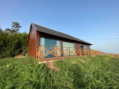 a house on a hill with a person standing in front of it at Casa Pereirinha in Estreito da Calheta