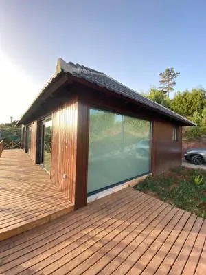 a small house with glass doors on a deck at Casa Pereirinha in Estreito da Calheta