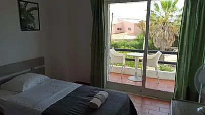 a bedroom with a bed and a balcony with a table and chairs at Casa da Torre Alta in Lagos