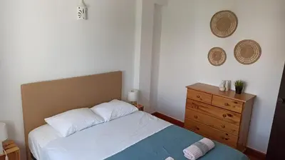 a bedroom with a bed and a wooden dresser at Casa da Torre Alta in Lagos