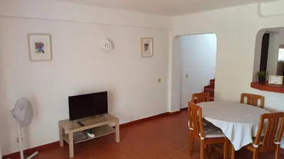 a living room with a table and a tv at Casa da Torre Alta in Lagos
