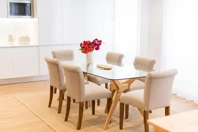 a dining room table with chairs and a vase of flowers at Apartamentos Fernão de Ornelas by Heart of Funchal in Funchal
